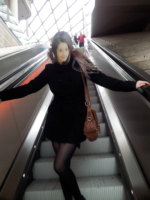 Yoona on escalator with curious members of the public